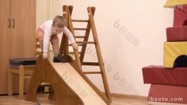 一个在室内操场上玩耍的小男孩从一个短斜坡上滑下来，一边玩耍一边试图保持平衡